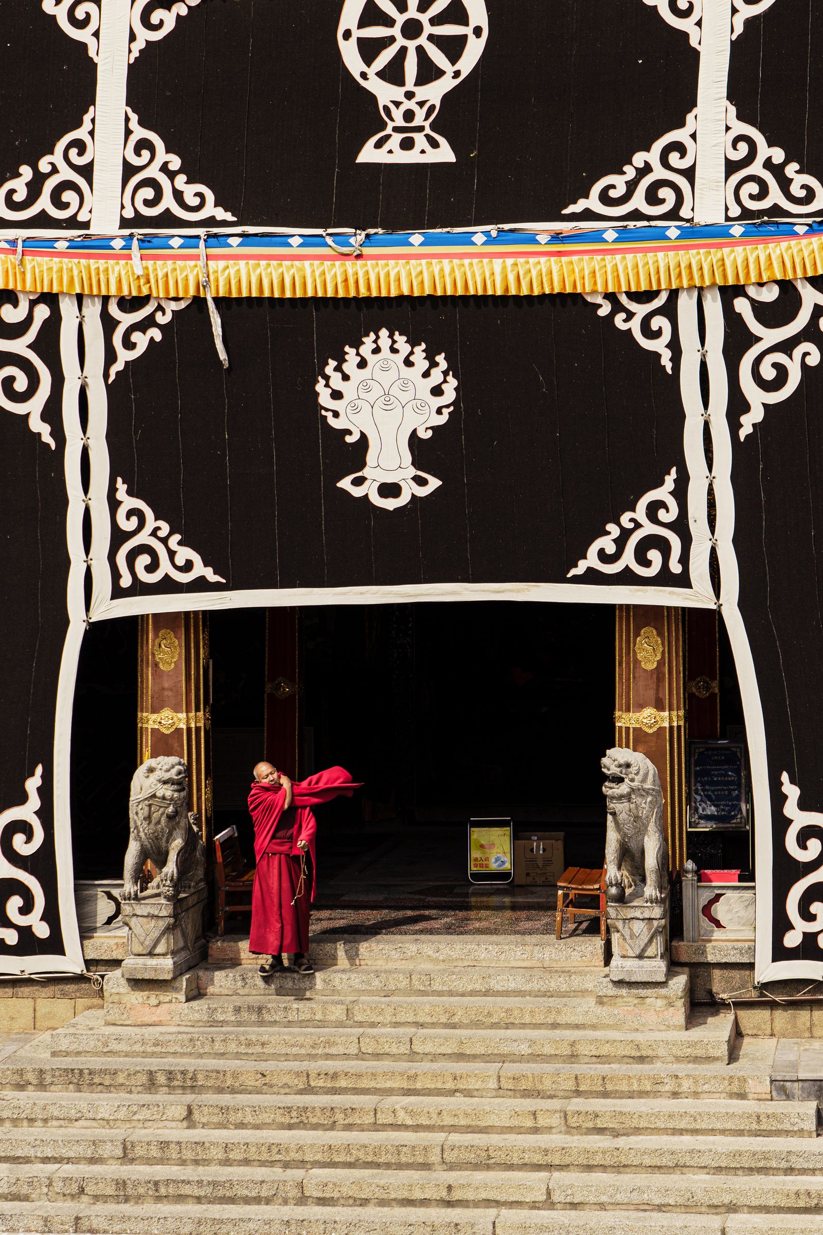 Monks framed by the ornamented entrance of Dongzhulin Monastery